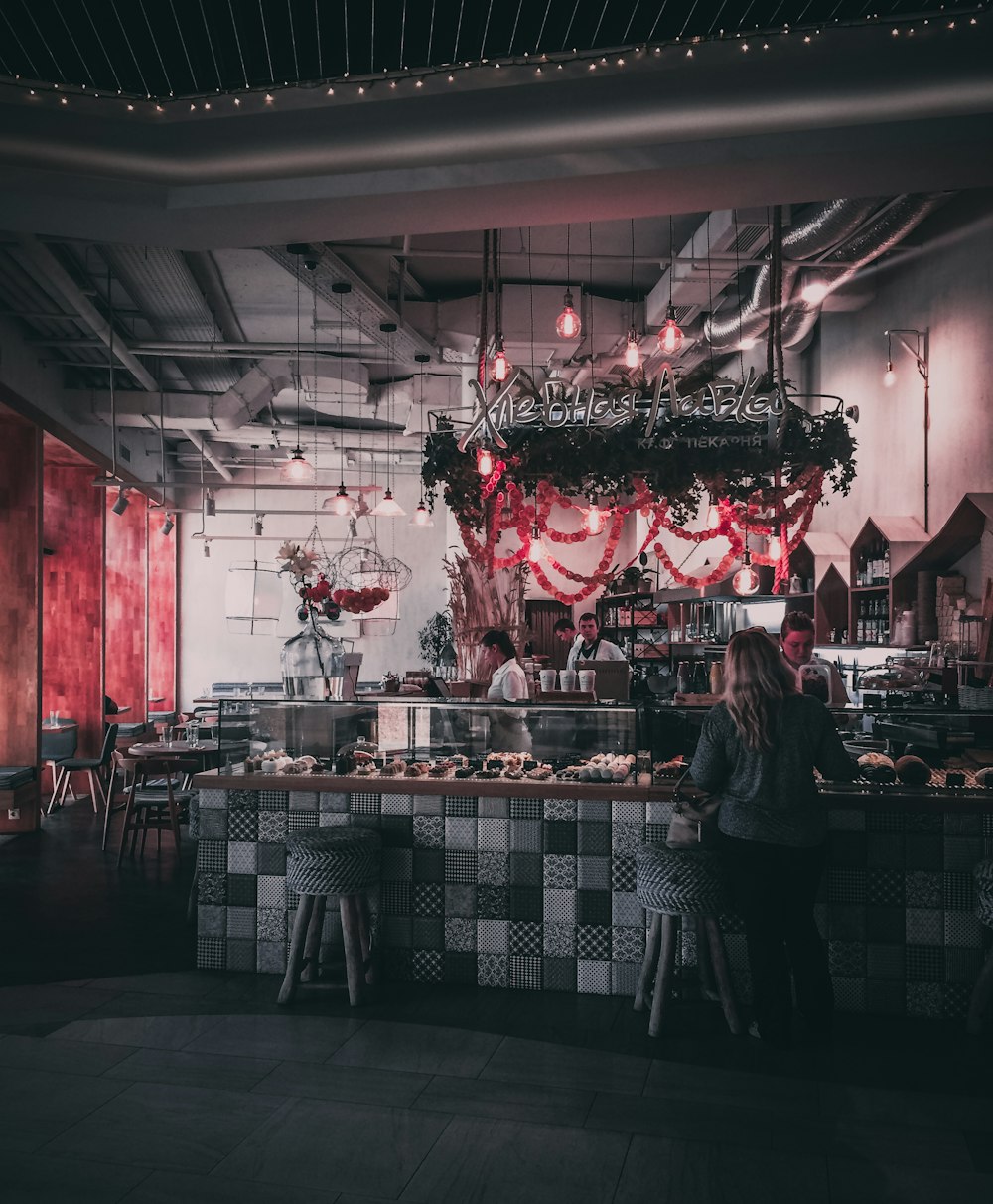 woman standing inside coffee shop near display shelf