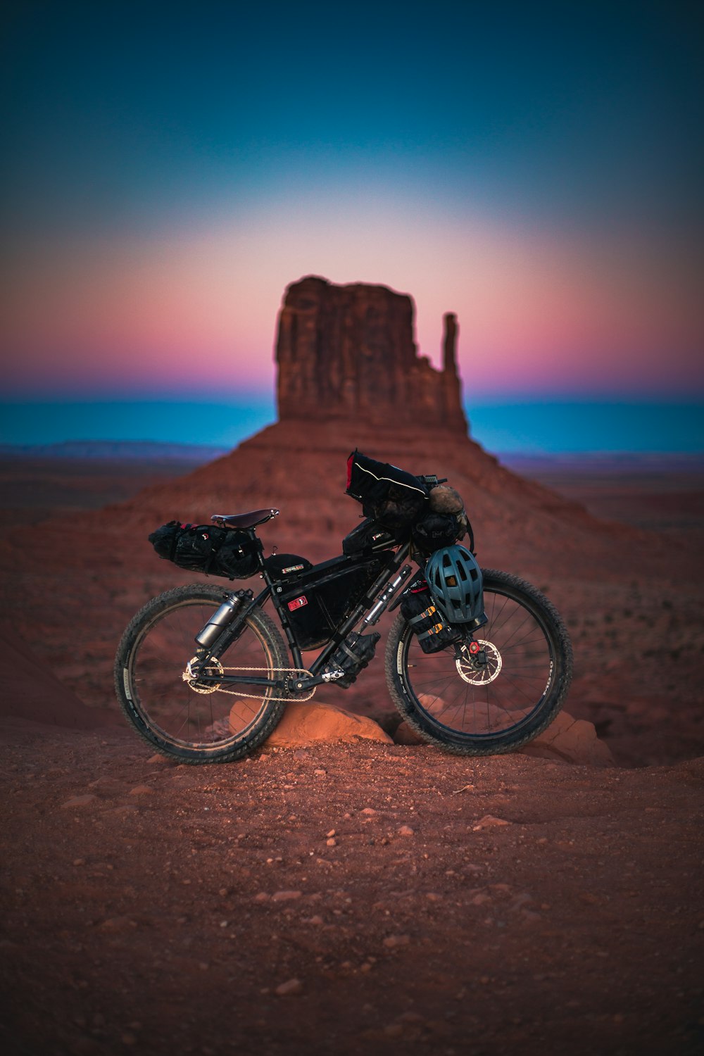 selective-focus of black mountain bike parked beside rock formation