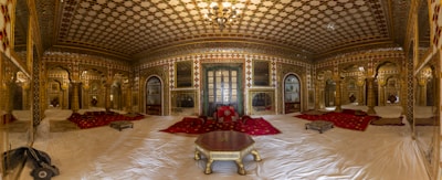 Traditional Arabic majlis seating with plush cushions and wall upholstery in rich gold tones.