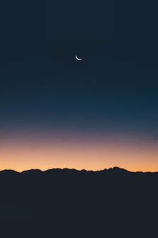 un paesaggio notturno al tramonto con la luna nel cielo