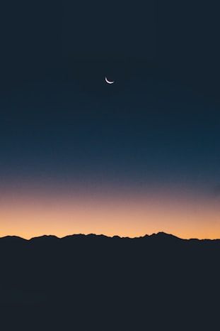un paesaggio notturno al tramonto con la luna nel cielo