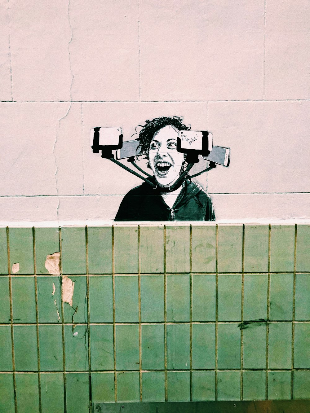mural painting of woman's face surrounded by smartphones