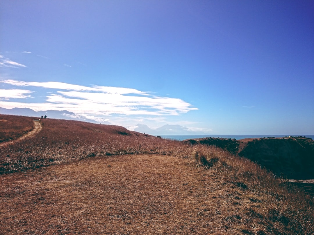 hill under blue cloudy sky