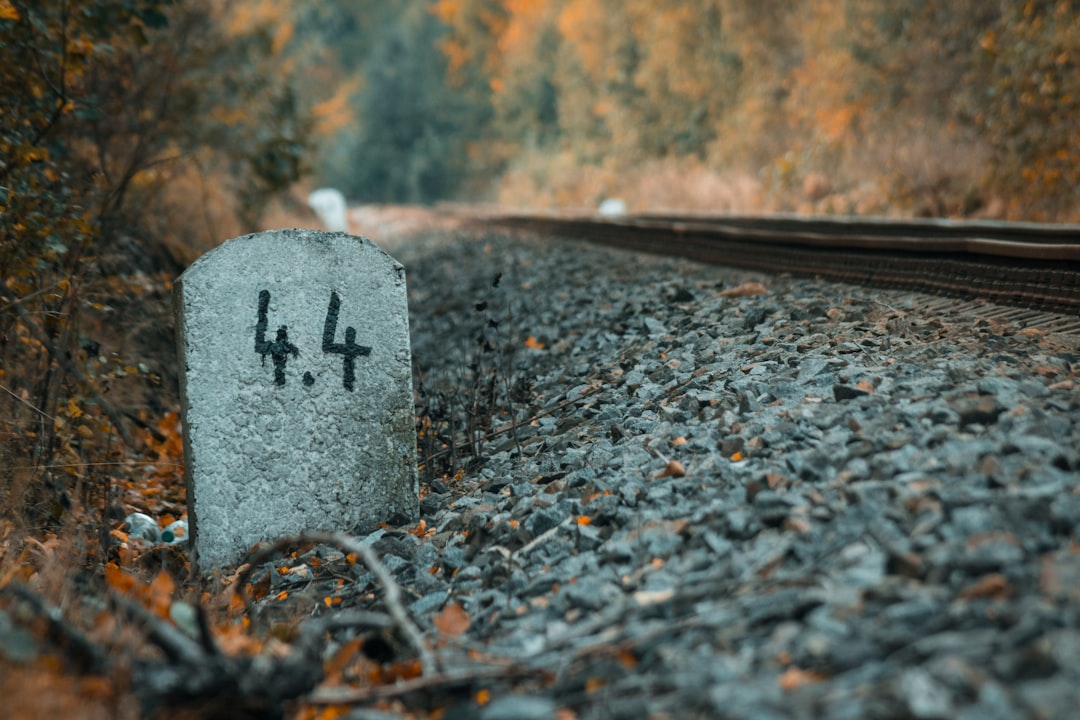 gray concrete tombstone near train rail