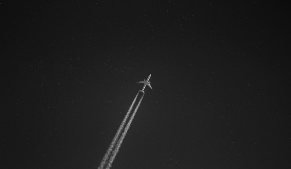 煙の軌跡を離れる白い飛行機