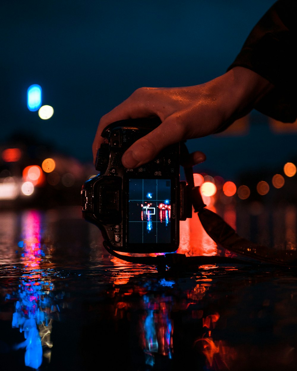 person holding black DSLR camera taking photo of LED lights