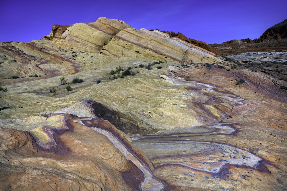 a view of a desert with a mountain in the background