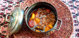 Traditional clay pot filled with slow-cooked beef stew and vegetables.