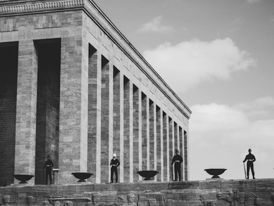 grayscale photo of men standing on hill near brick coliseum in Anıtkabir Turkey