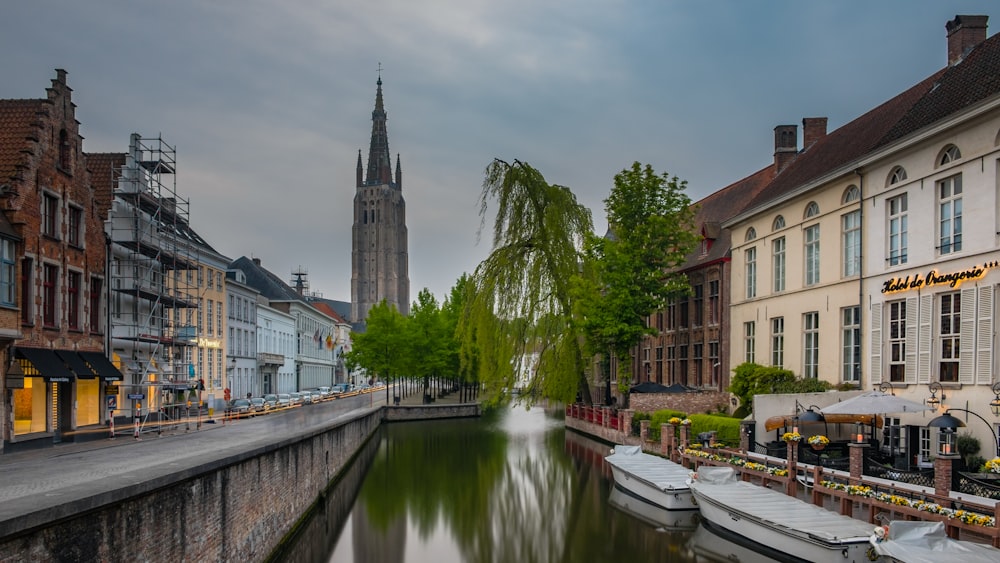 boats on river surrounded with building at daytime