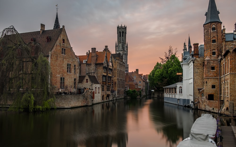 brown concrete buildings beside calm body of water