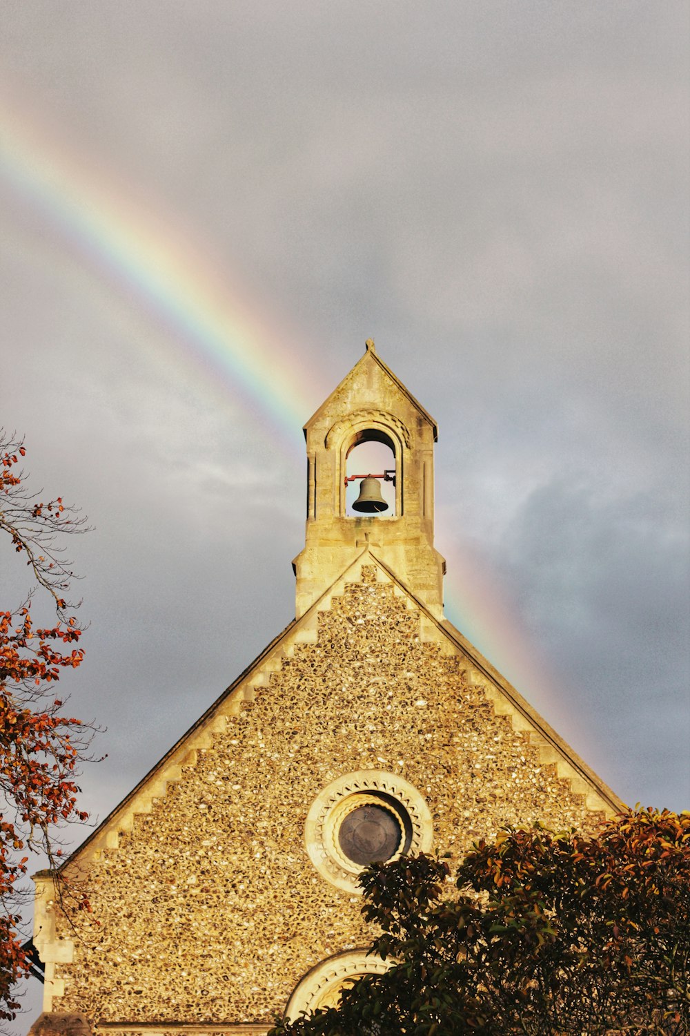 igreja marrom sob o arco-íris