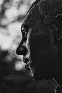 Close-up of a finely detailed bronze statue capturing lifelike human features.