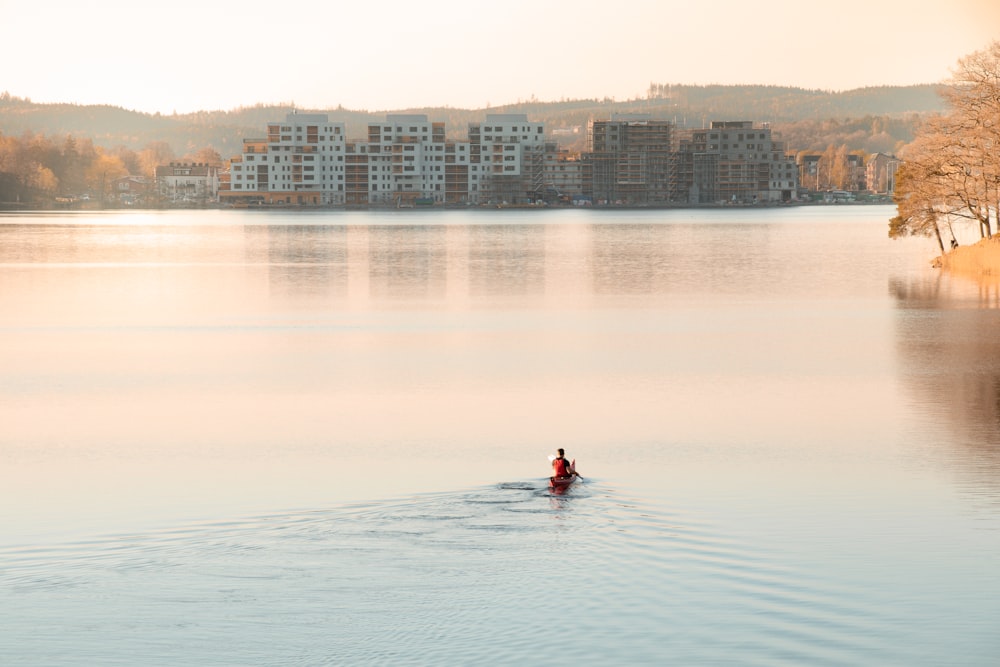 man riding on boat on calm body of water