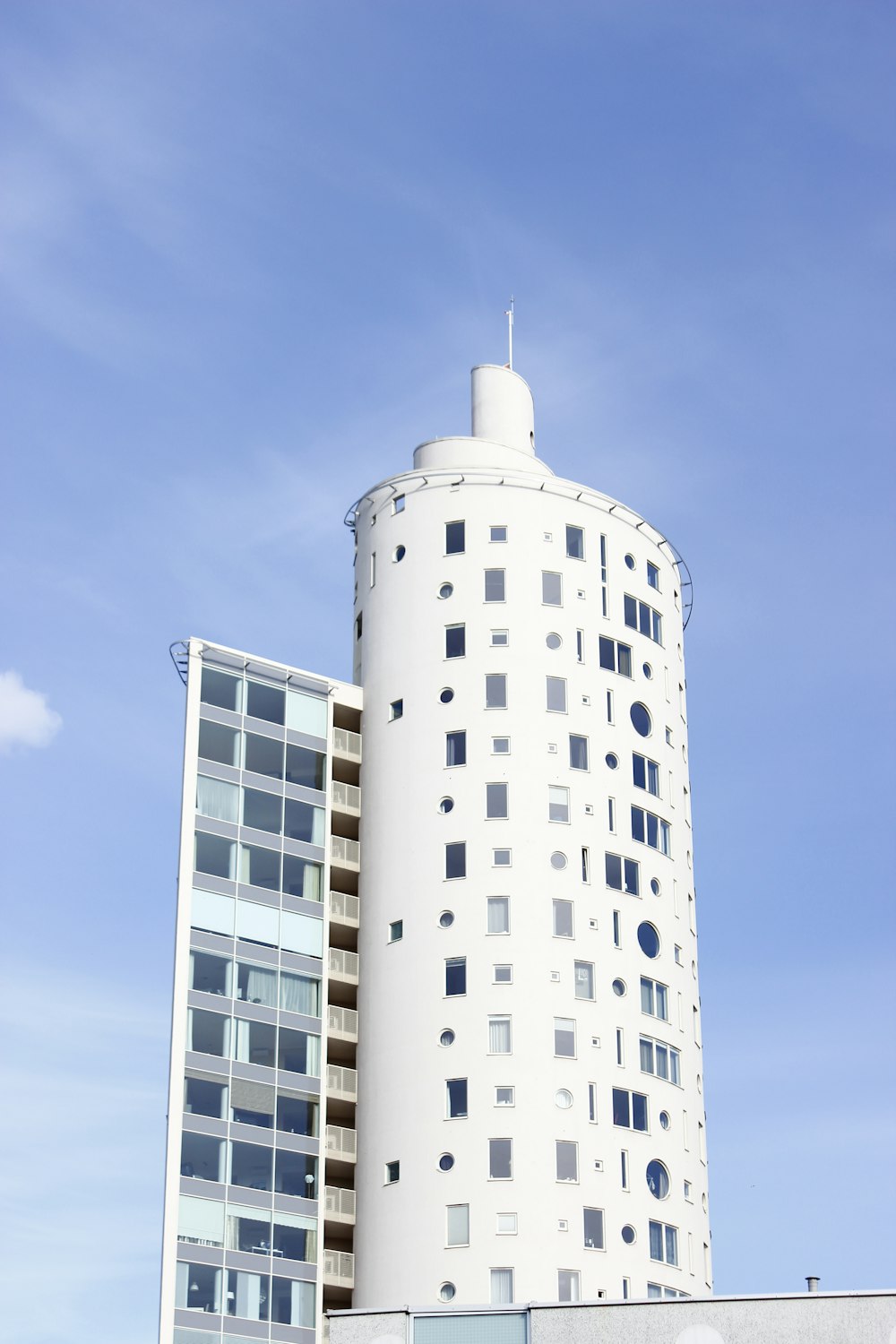 Edificio de la torre blanca bajo el cielo azul y blanco durante el día