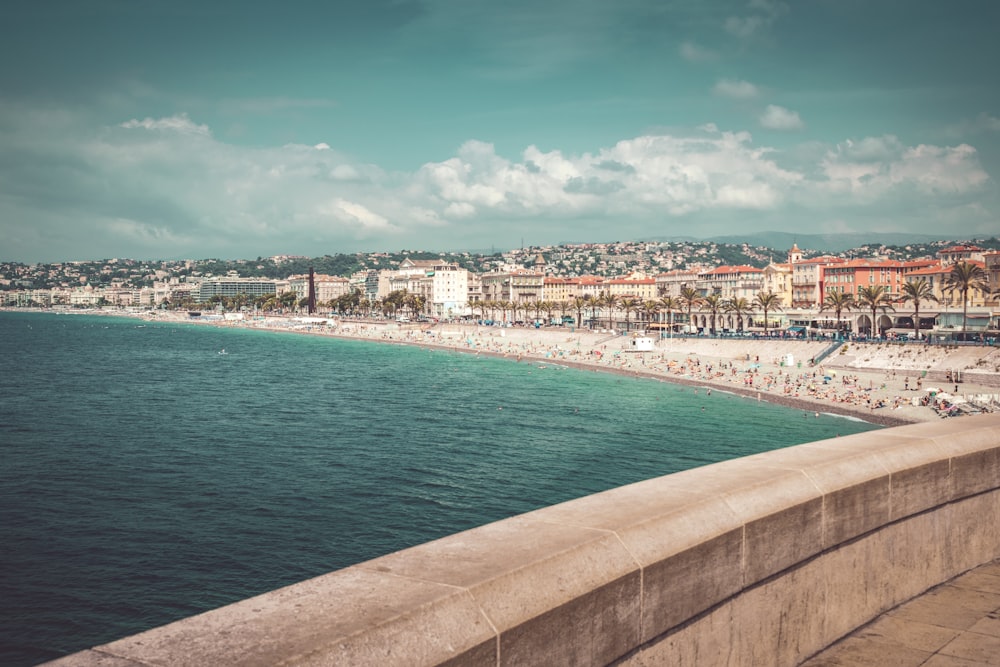 buildings near seashore under cloudy sky