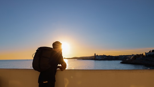 man leaning on wall while looking on sea in Sitges Spain