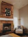 A cozy living room featuring a large, colorful fish art sign above the fireplace.