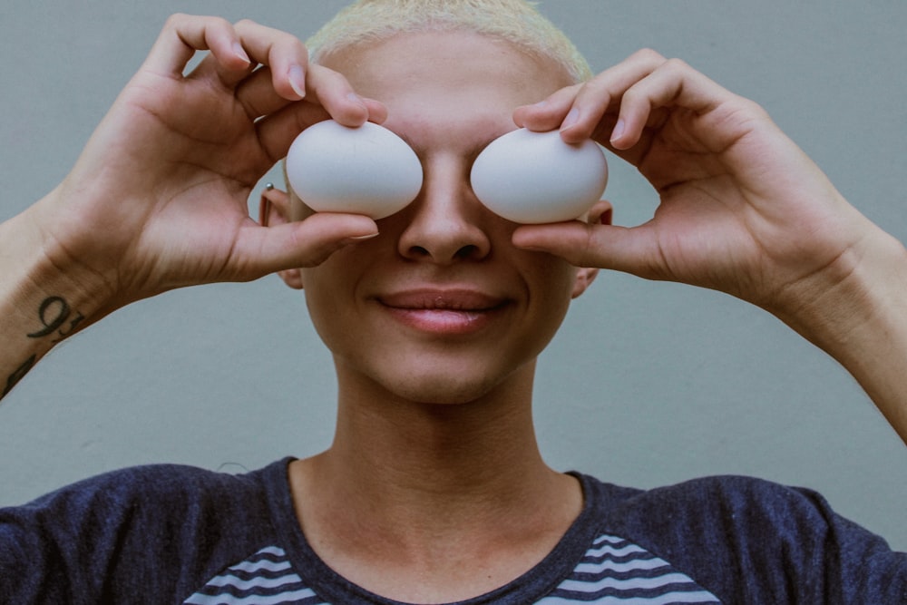 Mujer sosteniendo dos huevos blancos