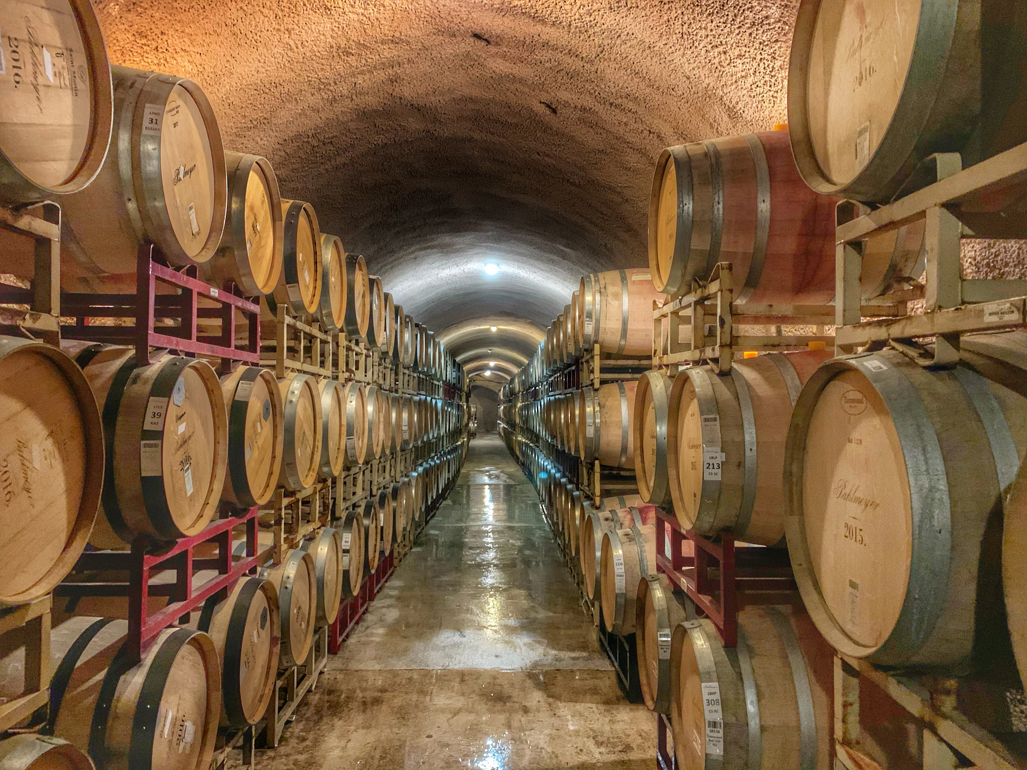 Oak barrels stacked in a dim cellar