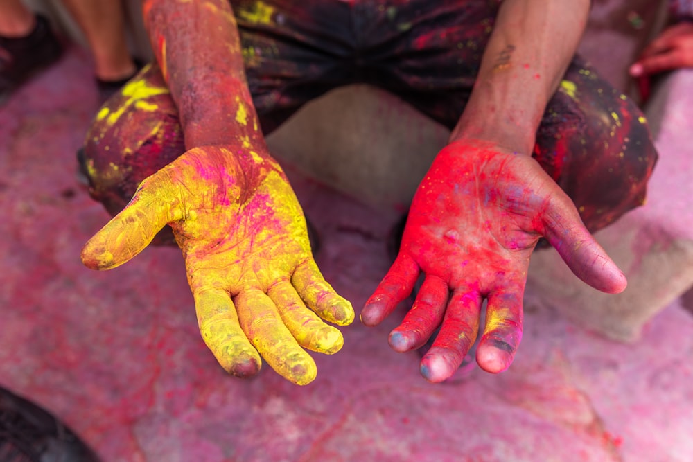 黄色と赤の粉を塗った人の手