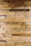 Numerous wooden planks arranged horizontally, showcasing a variety of natural patterns and textures. Some planks display darker stains and knots, adding character to the overall appearance.