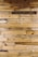Numerous wooden planks arranged horizontally, showcasing a variety of natural patterns and textures. Some planks display darker stains and knots, adding character to the overall appearance.