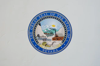 The Great Seal of the State of Nevada logo on white wall