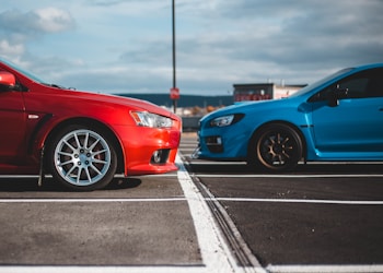 blue and red cars in parking lots