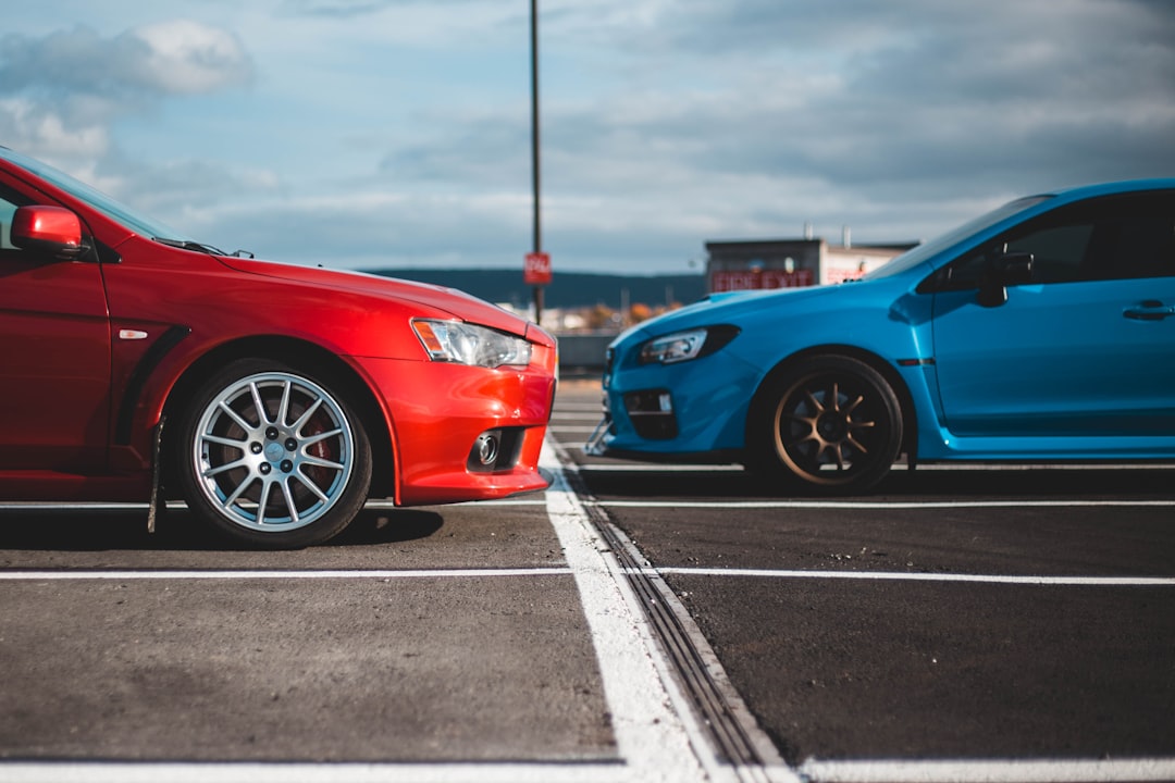 blue and red cars in parking lots,