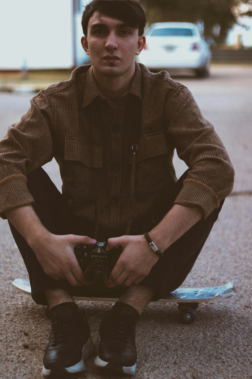 man sitting on skateboard deck