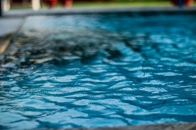 Close-up of crystal-clear water reflecting the deep blue sky in a high-end pool
