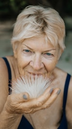 woman holding white-petaled flower