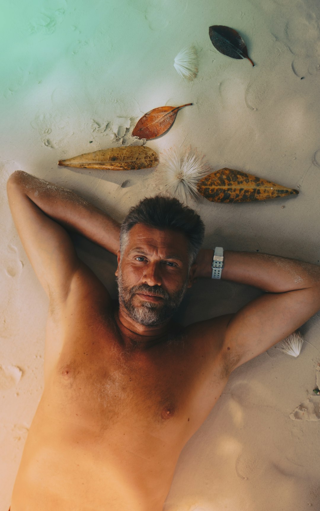 topless man lying on sand