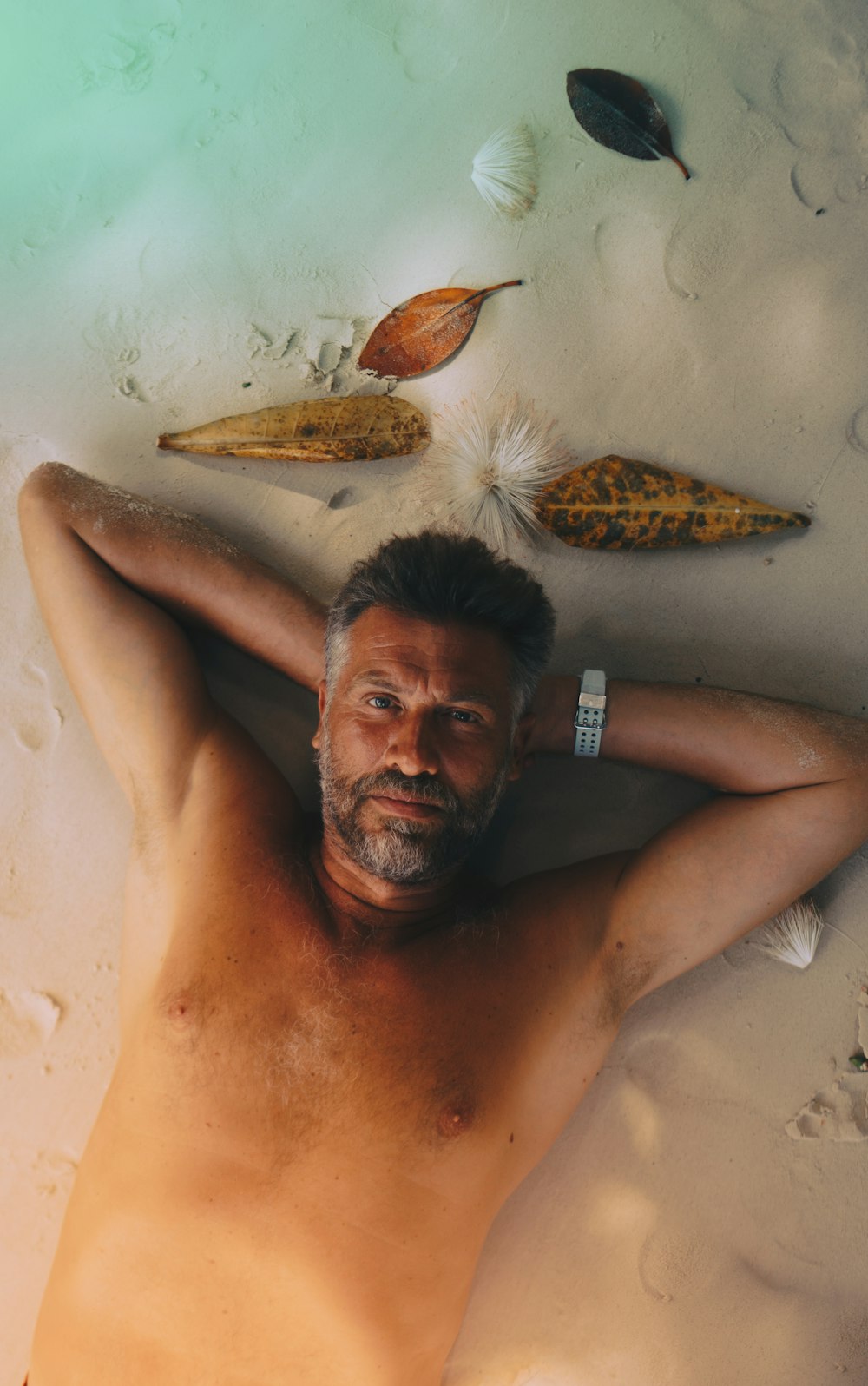 topless man lying on sand