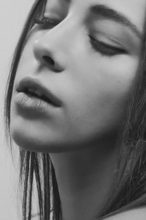 Soft focus portrait of a woman enjoying a moment of self-care with a facial mask on