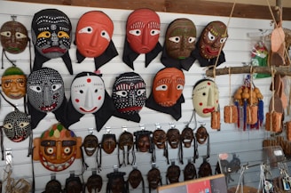 Colorful handcrafted African masks displayed on a wooden wall.