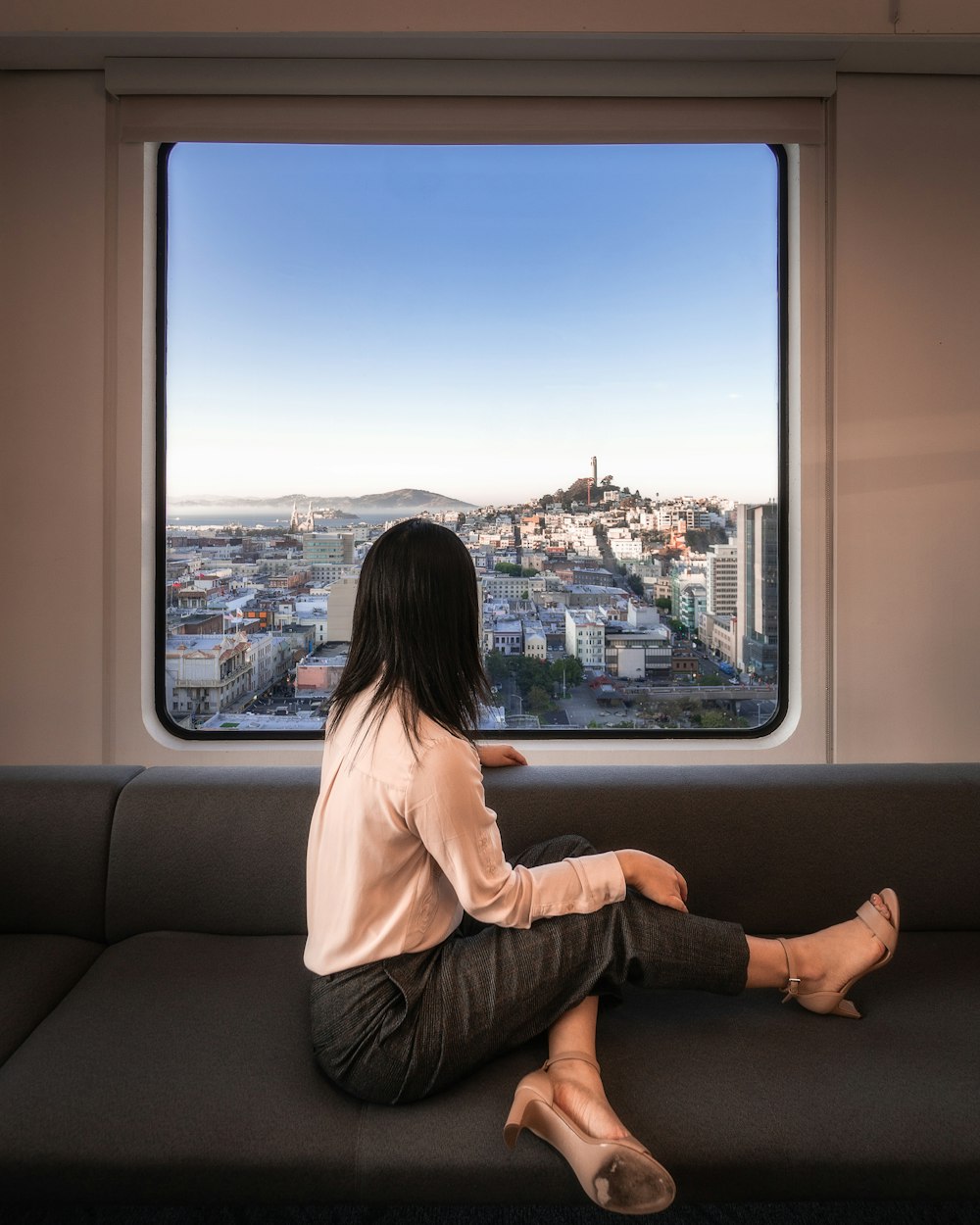 woman sitting on sofa near window