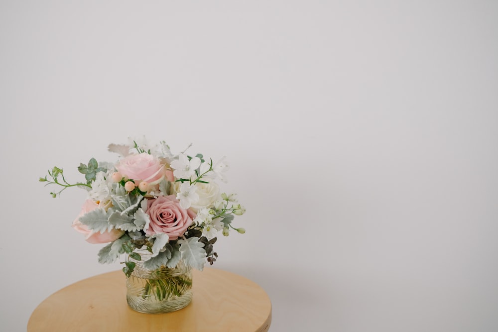 a vase of flowers sitting on top of a wooden table