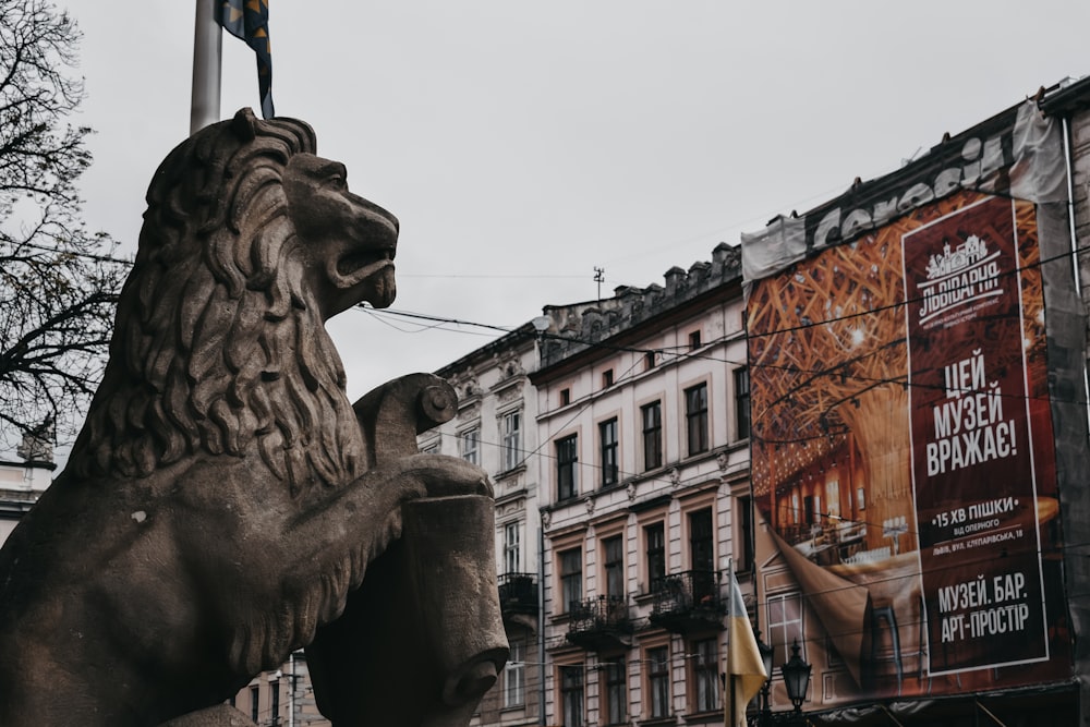 brown lion statue near white and brown building during daytime