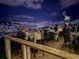 Guests enjoying a sophisticated networking dinner with city views at sunset.