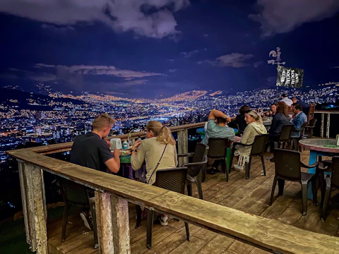 Guests enjoying a sophisticated networking dinner with city views at sunset.