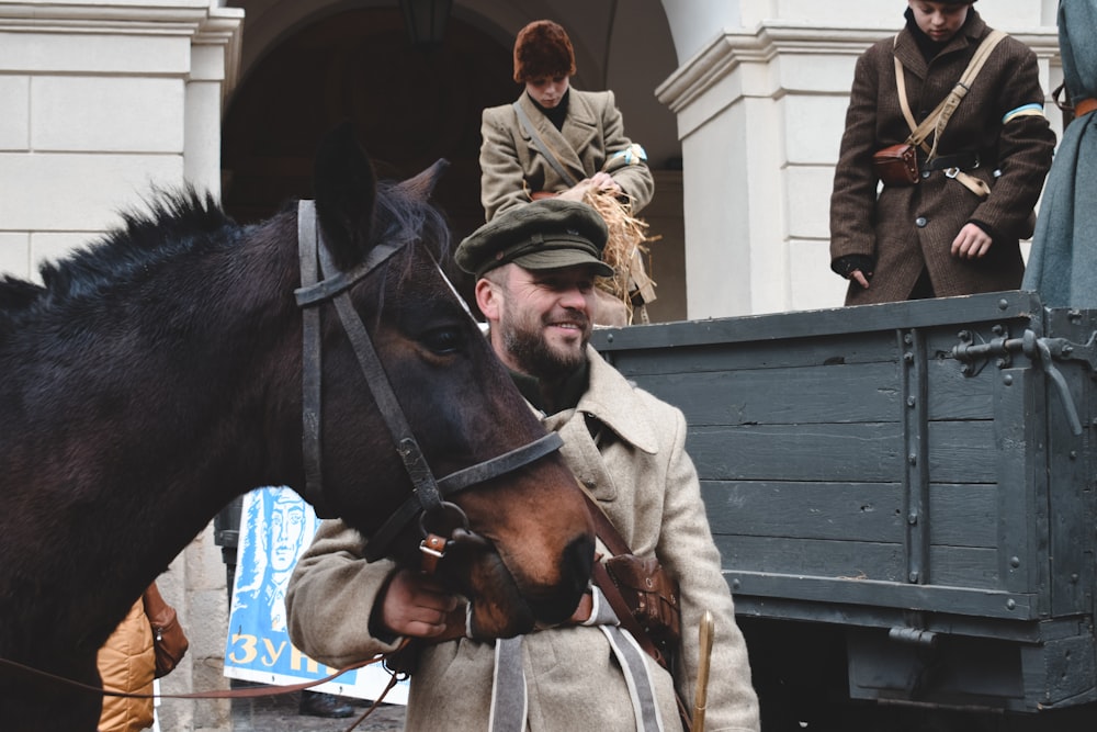 man standing beside black horse during daytime