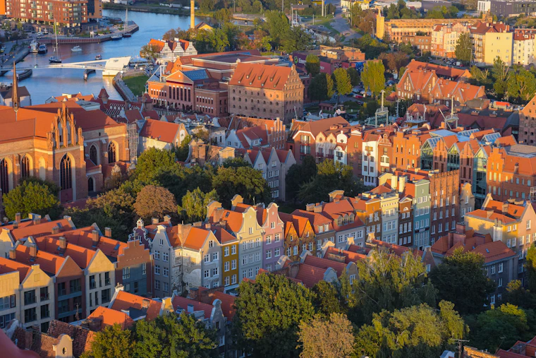 Aerial view of Gdańsk's waterfront townhouses beside the river