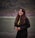 woman wearing black blazer standing and smiling near body of water
