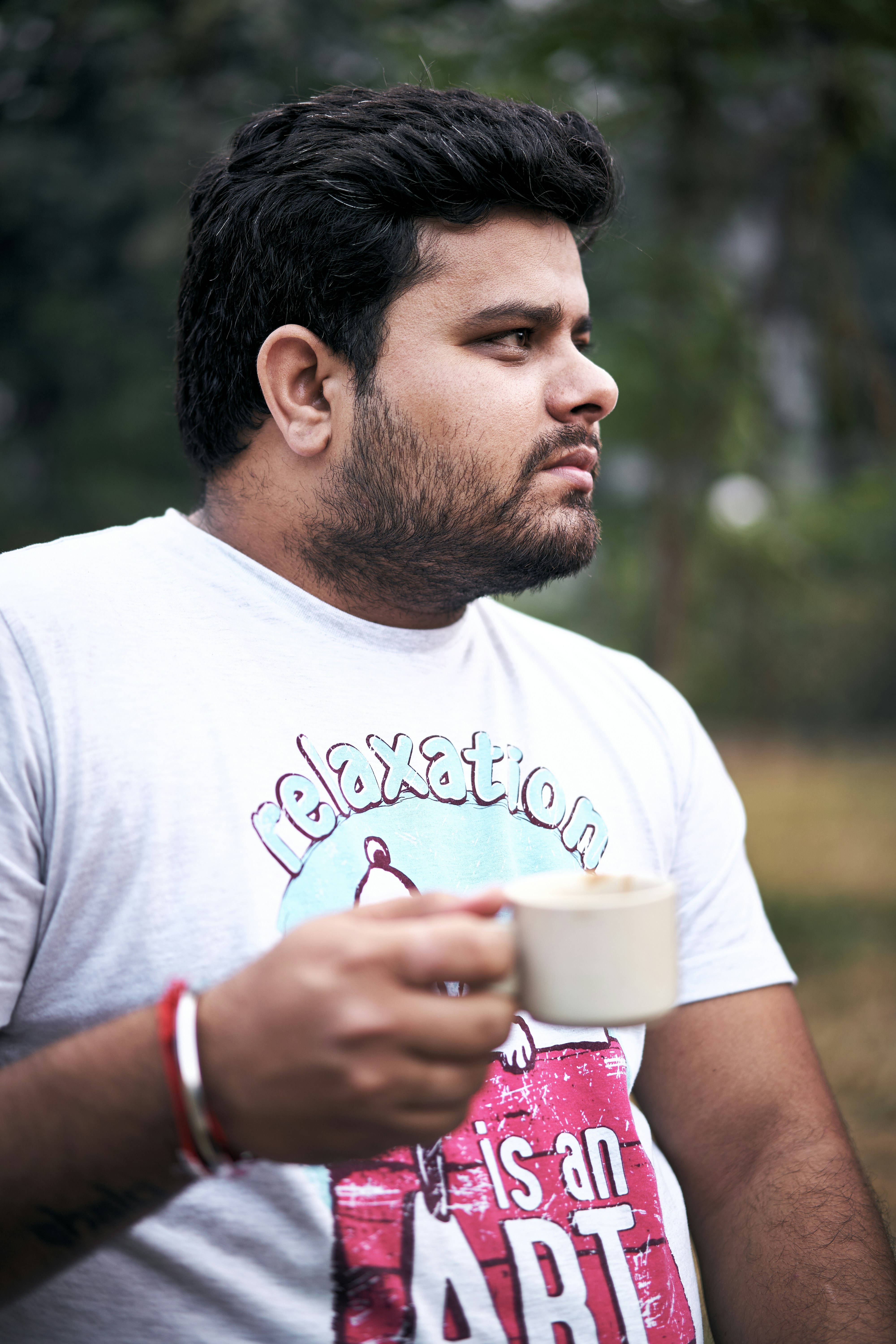 selective focus photo of man holding teacup