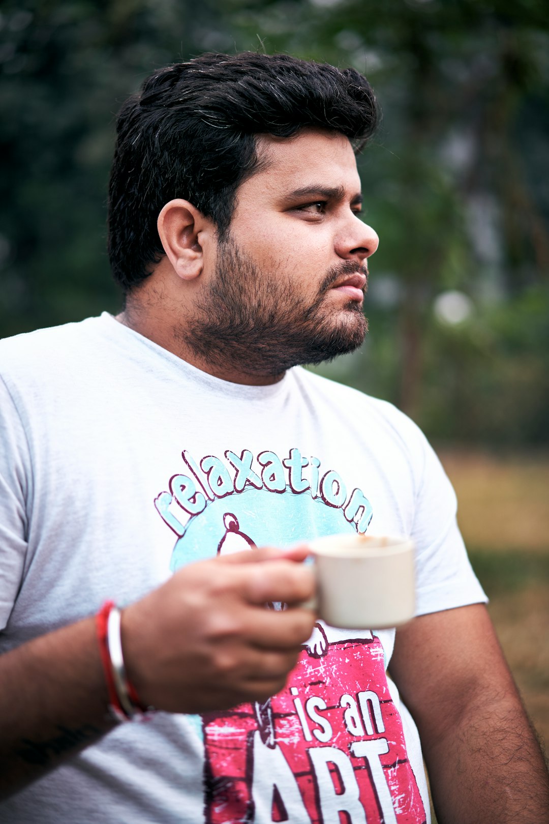 selective focus photo of man holding teacup