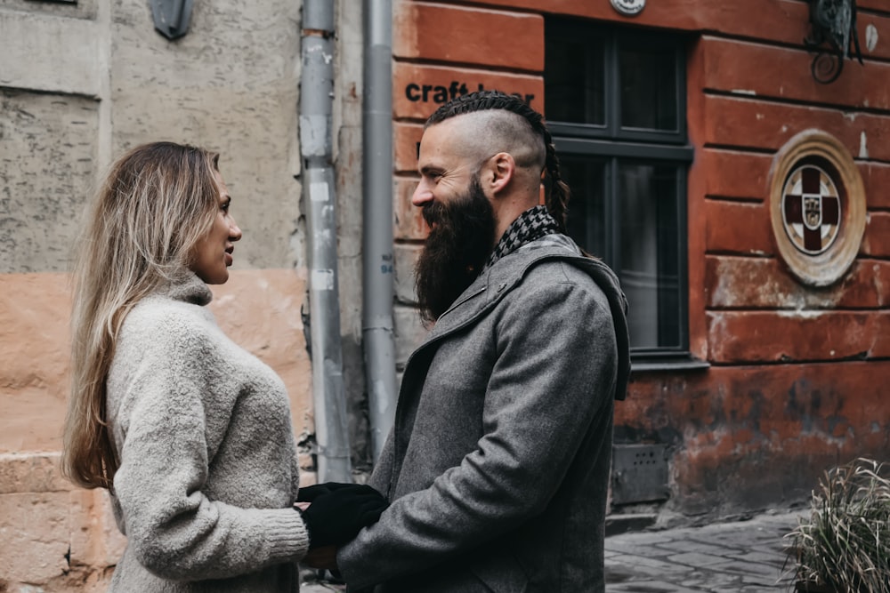 man and woman standing beside building