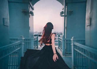 woman in black sheer lace spaghetti strap dress standing indors