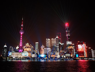 A sleek, modern cityscape illuminated with pink-red and white lights representing smart technology integration.